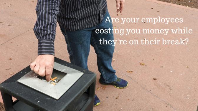 A hand putting out a cigarette in a public ashtray