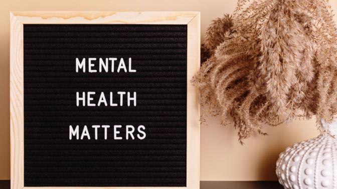 A picture of a plant next to a sign that says "Mental Health Matters"