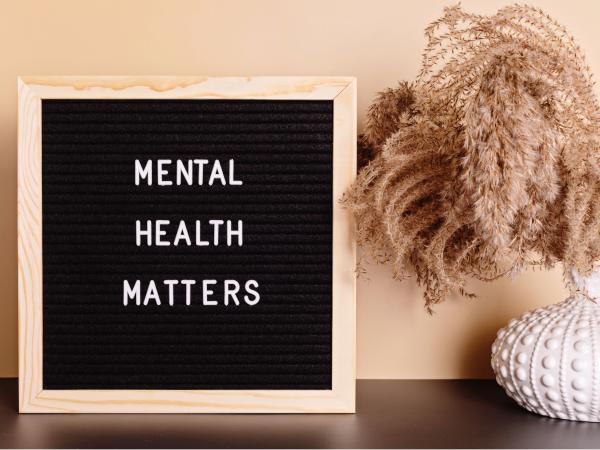 A picture of a plant next to a sign that says "Mental Health Matters"