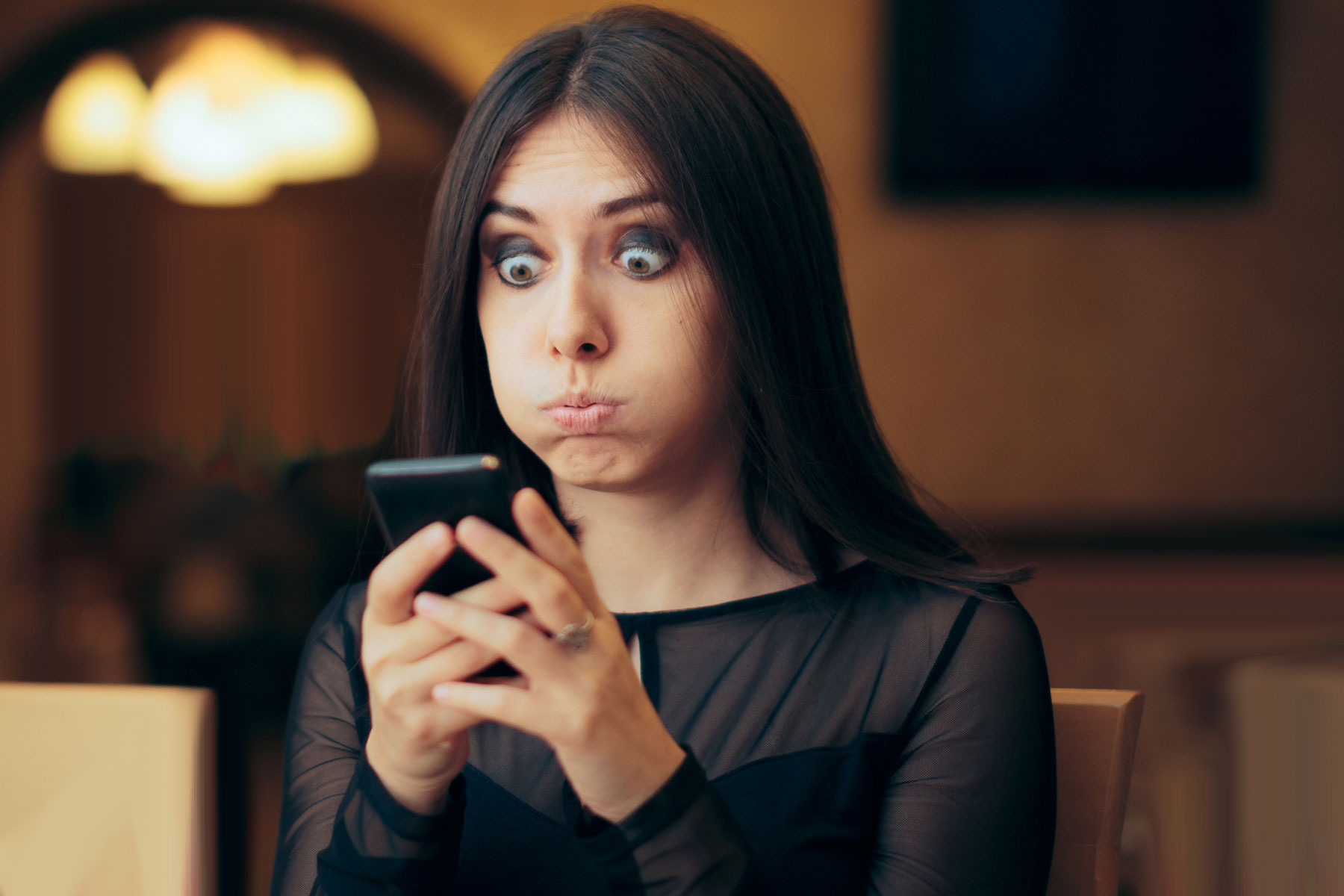 Woman looking at phone in confusion